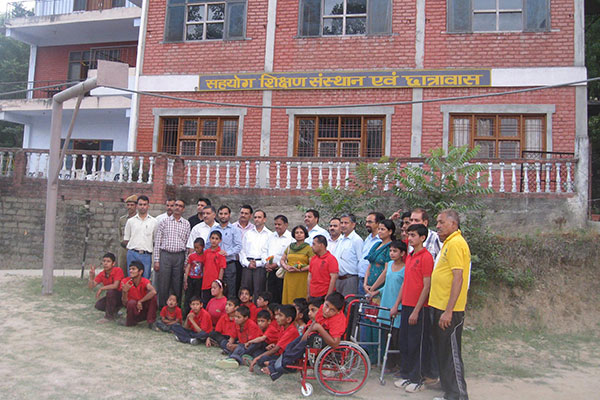 Intellectually disabled individuals posing in front of school
