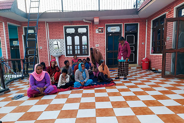 Multiple women sitting on an orange and white checkered floor