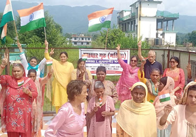 Women standing in a group holding Indian flags in the air